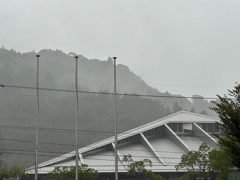 曇っている山と建物雨が降っている